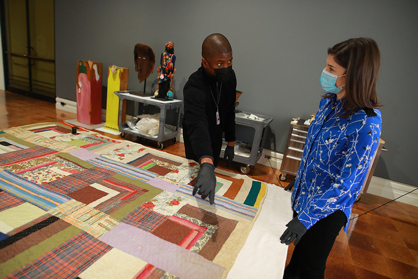 UToledo student Ufuoma Ogbemudje explaining a piece of art to a person